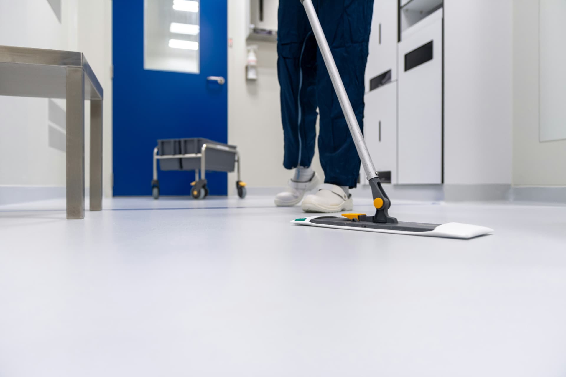 Worker mopping a spotless white floor after construction